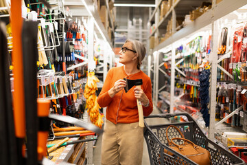 Woman shopping for tools in a hardware store, exploring options for DIY projects during the day