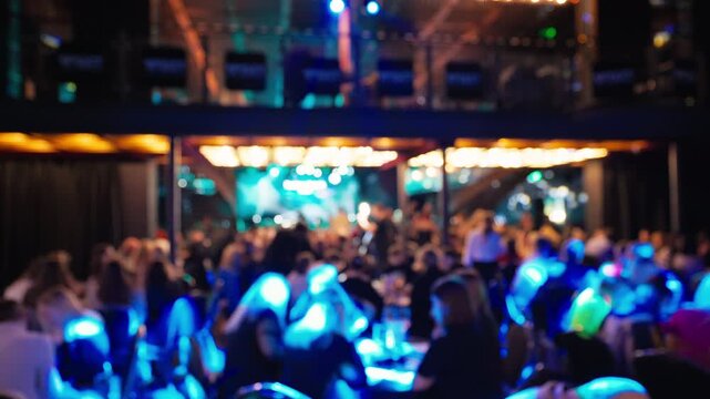 Participants sit under gentle illumination at charitable banquet with speeches and soothing ambient tunes