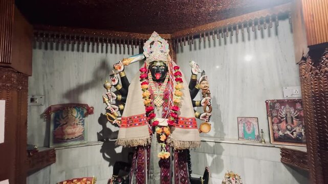Kali Mata idol with vibrant flower garlands and ceremonial attire inside a temple interior, representing strength, devotion, and Hindu spiritual tradition.
