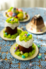 Easter traditional food for Russia: colorful painted Easter eggs, Eastre cakes, tradition Russian cottage cheese dish called Easter with chocolate on laid table with blue lace tablecloth