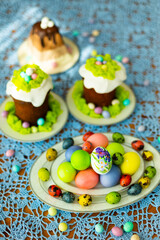 Easter traditional food for Russia: colorful painted Easter eggs, Eastre cakes, tradition Russian cottage cheese dish called Easter with chocolate on laid table with blue lace tablecloth