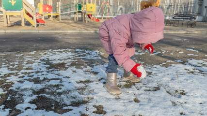 Fototapeta premium little girl playing on the playground on a winter day