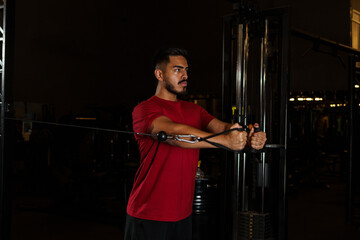 Man Performing Standing Cable Chest Fly Exercise in Gym