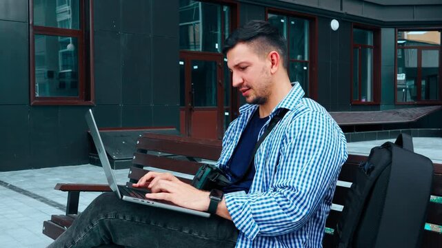 Working on a laptop outside at a modern building in the city