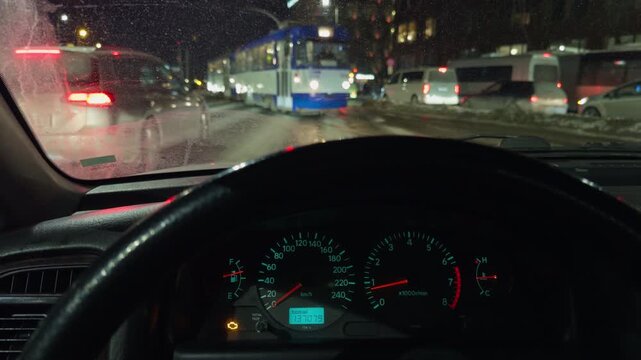 Vehicle halted at busy urban intersection. Idle automobile beneath streetlights with visible exhaust vapor