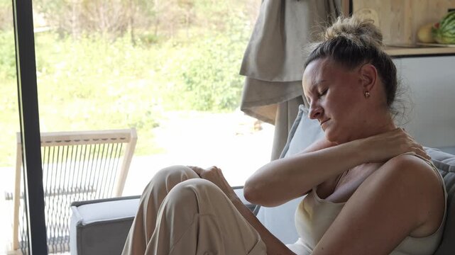 Home recovery woman relieving neck pain in personal space showing pain impact on daily life Quiet rest supports healing process reducing pain through relaxation wellness routine emotional balance