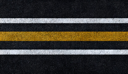 Top down view of a black asphalt road with yellow edge lines and white horizontal stripes, for designers needing clean transport textures as backgrounds for web, print and urban layouts © chaiwat