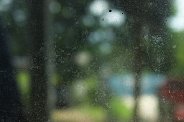 The surface texture of the glass is dirty and blurry with a colored background