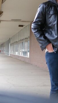 Man in Leather Jacket Walks By Camera - Vertical.
