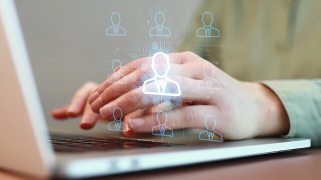 Hands typing on a laptop with digital icons representing people connected by technology in an office setting.