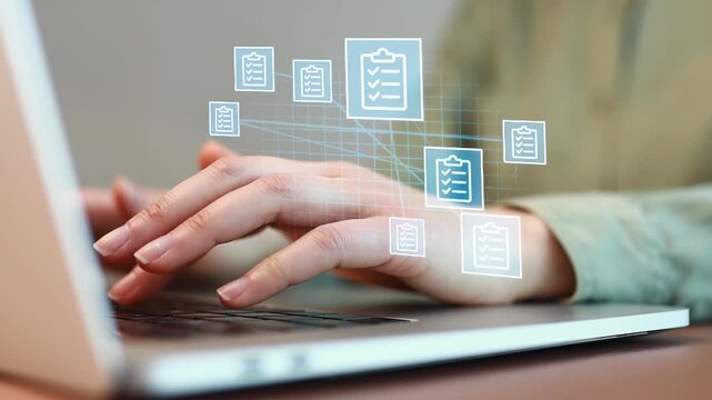 Hands type on laptop while images of checklists appear above the keyboard during work in a home office setting.
