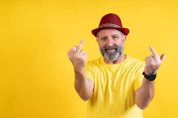 Smiling man showing middle fingers expressing defiance
