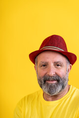 Mature man smiling wearing red fedora hat