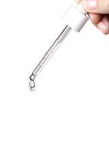 Obraz premium Pipette with serum in hand. Drips drop isolated on white background, copy space vertical photo close up