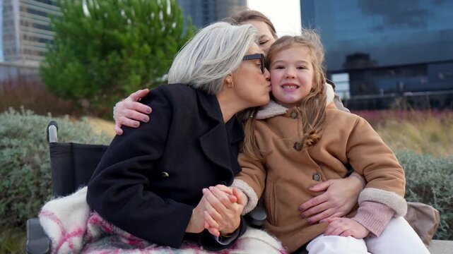 Three generations of women embracing in a city park