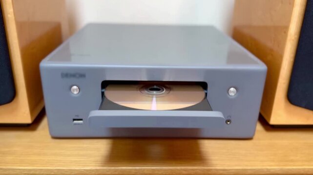 person putting disc into cd player music stereo then pushing close tray button