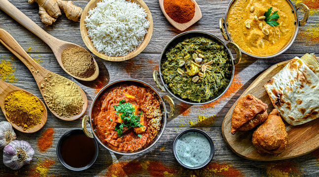 Composition with indian dishes: madras paneer, palak paneer and shahi paneer with basmati rice served in original indian karahi pots