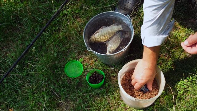 Stylized fisherman preparing bait near bucket with fresh catch fish