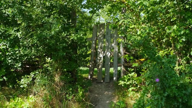 Stylized rustic wooden gate in a lush green secret garden.
