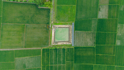 Aerial view of an irrigation pond equipped with a solar panel system used for water distribution across surrounding farmland. © Mr