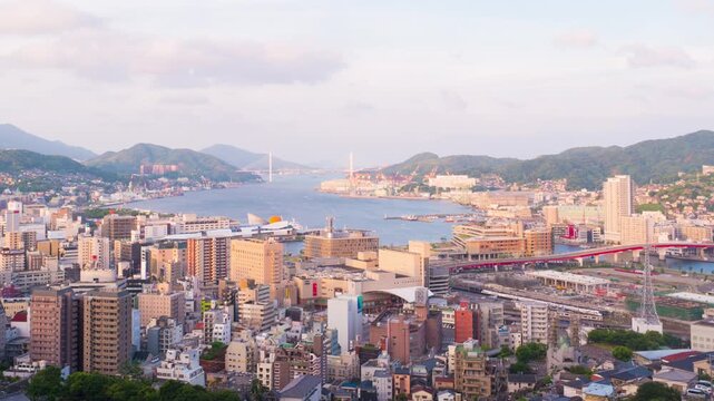 Nagasaki, Japan. Aerial timelapse made from a hill in Nagasaki, Japan, with a view over the entire center, including the bay and the hills. Cloudy and sunny day in summer, panning video