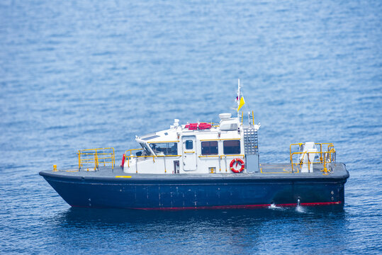 Small pilot vessel navigating over smooth blue sea in daylight.