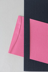 pink card inserted into black paper edge