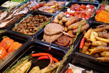 Sausages and frankfurters, fried potatoes, vegetables. Various foods