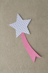 star with heart pattern and pink star tail on textured brown paper