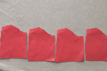 torn red paper shapes on brown