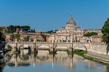 Fototapeta premium Italy - Rome - Tiber River - Sant'Angelo Bridge mirrors in calm waters beneath St Peter's Basilica dome on Roman skyline