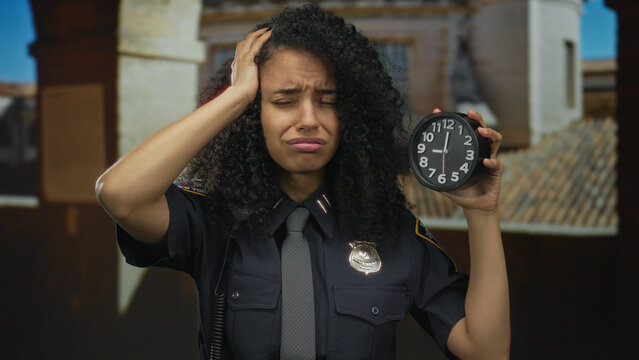 Woman police officer holds clock looking stressed on old town street, conveying urgency and responsibility in uniformed duty.