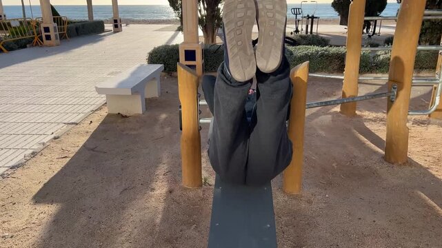semicircular de hombre 50+ ejercit&aacute;ndose en m&aacute;quina de step al aire libre