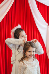 Older sister adjusting younger sister's hairbow