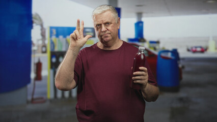 Man holding a bottle of pomegranate juice, hand raised and speaking in a building forecourt by fuel pumps  health concern. © Krakenimages.com