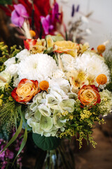 Obraz premium Vibrant mix of roses, hydrangeas, and chrysanthemums forms lush bouquet. Garden-style bouquet, wedding floral trends, natural aesthetics.