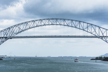 Fototapeta premium Balboa bridge marking the Pacific entrance to the Panama Canal under cloudy sky, key maritime gateway for global shipping.