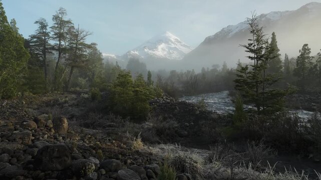 Vivid Landscape of Snow Capped Volcano Overlooking a River and Forest. Lanin National Park, Argentina