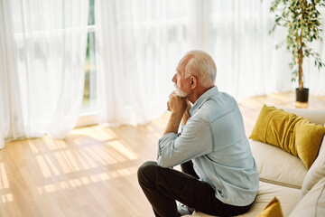 Portrait of a serious sad mature old man at home