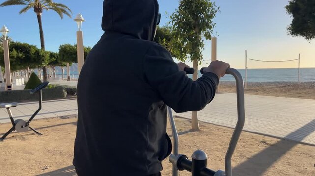 Hombre 50+ ejercit&aacute;ndose en bicicleta est&aacute;tica con toma frontal al aire libre