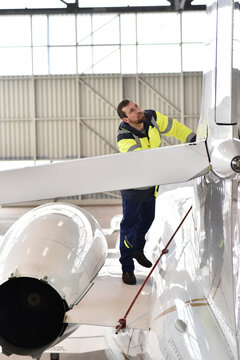Aircraft mechanic inspects and checks the technology of a jet in a hangar at the airport