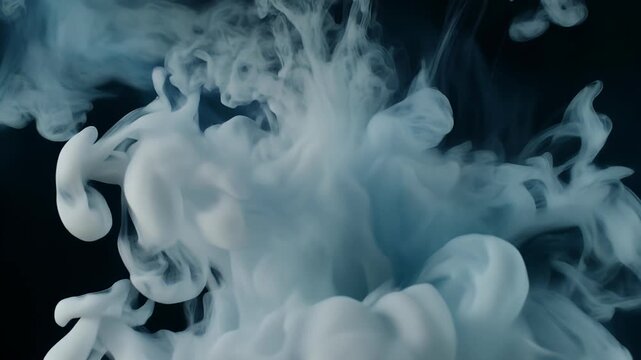 Abstract white smoke or ink swirling and dissolving in dark water, creating ethereal patterns and textures.