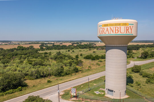 Aerial Drone View of Granbury, Texas Water Tower Near Green Fields and Rural Roads