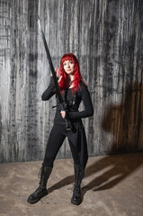 Naklejka premium Dark fantasy beautiful redhaired woman with sword against grunge wall