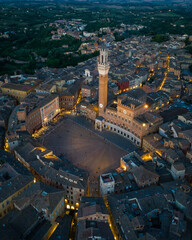Naklejka premium Aerial view of Piazza del Campo in Siena with city lights glowing around the medieval square. Iconic historic landmark in Tuscany, Italy, known for its unique shell shape and cultural heritage