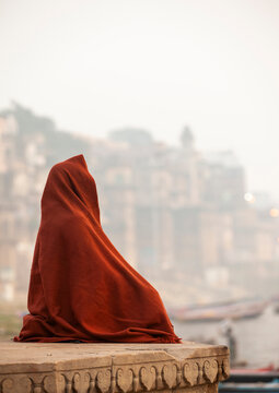 Man covered with a blanket meditating on riverbank, Uttar Pradesh, Varanasi, India