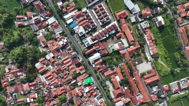 Aerial View of Dense Residential Area in Indonesia with Red Tile Roofs and Clear Blue Sky