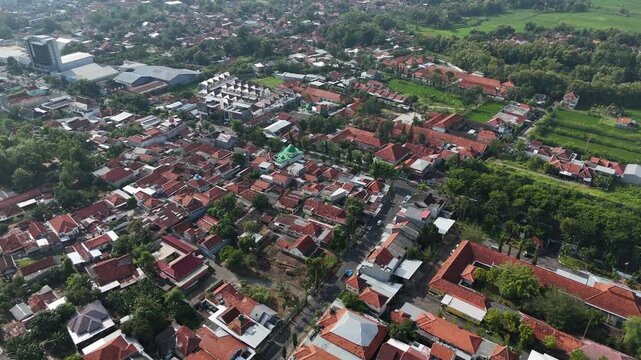 Aerial View of Dense Residential Area in Indonesia with Red Tile Roofs and Clear Blue Sky