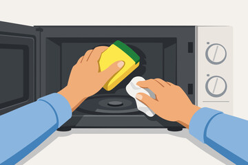 Obraz premium Cleaning microwave oven interior at home using a sponge and cloth for hygiene