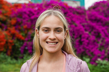 Happy young caucasian girl smiling on camera after yoga class at city park - Blond woman portrait...